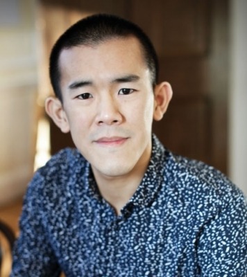 A headshot of a man in a blue button down shirt